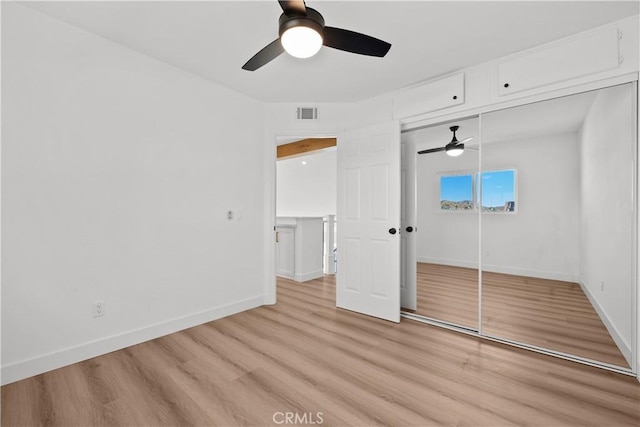 unfurnished bedroom featuring ceiling fan, light hardwood / wood-style flooring, and a closet