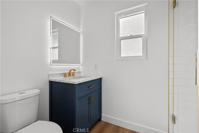 bathroom featuring vanity, walk in shower, toilet, and hardwood / wood-style floors