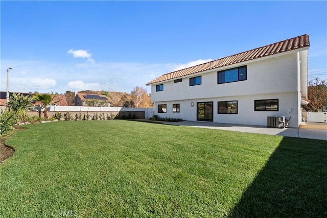 back of property featuring a patio, a yard, and central AC