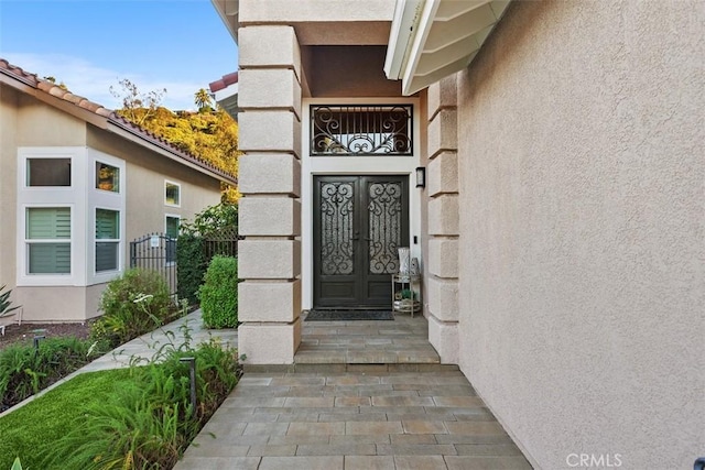 view of exterior entry with french doors and stucco siding