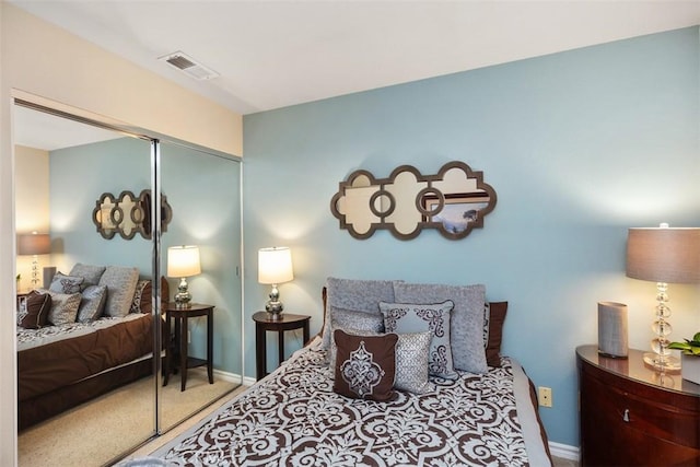 carpeted bedroom featuring visible vents and a closet