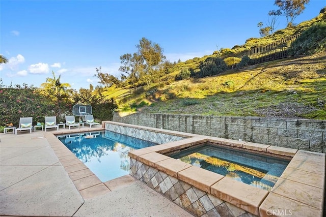 view of pool with a patio area, a fenced backyard, a fenced in pool, and an in ground hot tub