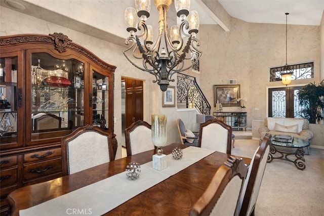 carpeted dining space featuring a high ceiling, visible vents, french doors, beamed ceiling, and an inviting chandelier