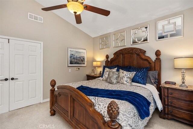 bedroom with visible vents, light colored carpet, lofted ceiling, ceiling fan, and a closet