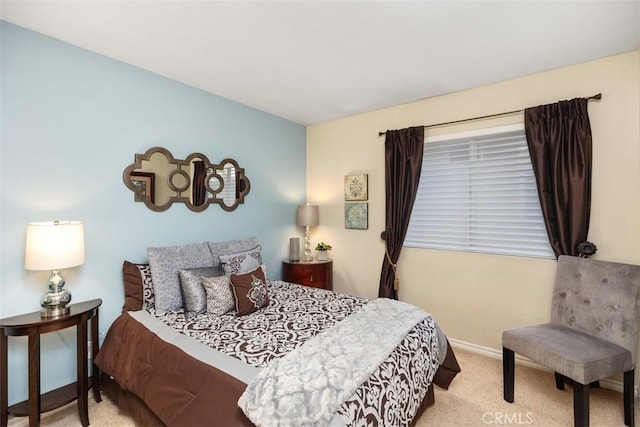 bedroom featuring light colored carpet and baseboards