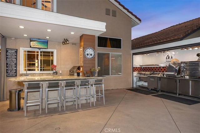 view of patio featuring area for grilling and outdoor wet bar