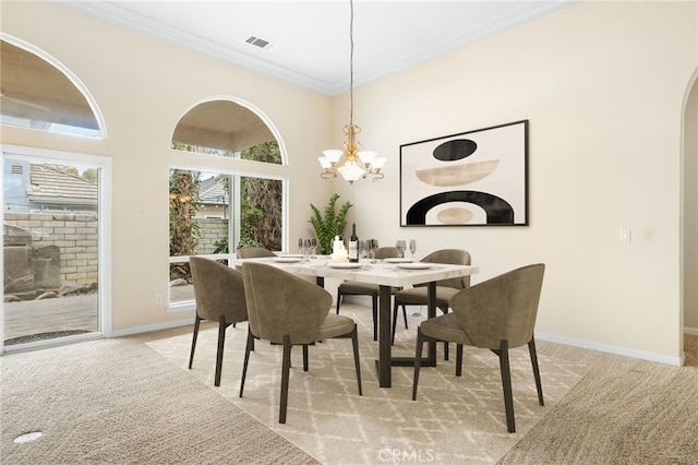 carpeted dining room featuring ornamental molding, a chandelier, and a high ceiling