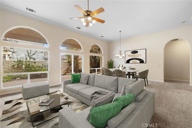 living room with ceiling fan with notable chandelier, light colored carpet, and ornamental molding