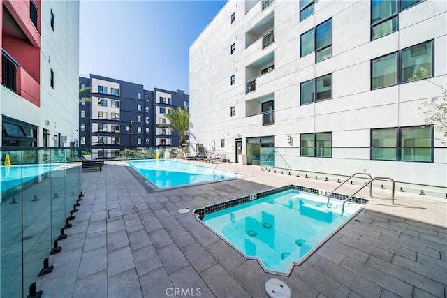 community pool featuring a community hot tub and a patio area
