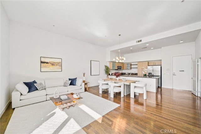 living area featuring an inviting chandelier, visible vents, wood finished floors, and recessed lighting