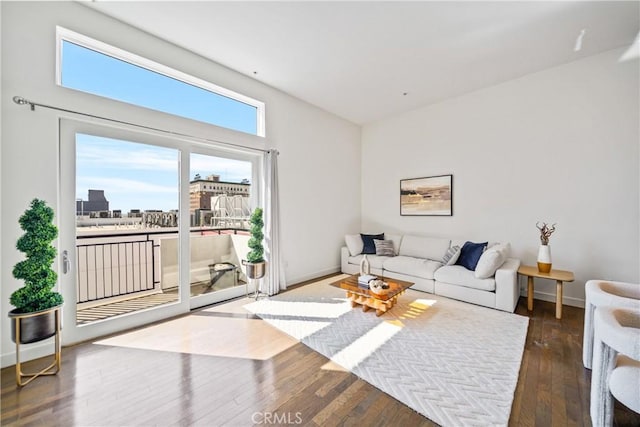 living room featuring a city view, hardwood / wood-style floors, and baseboards