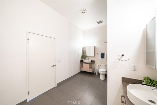bathroom featuring toilet, vanity, tile patterned floors, and visible vents