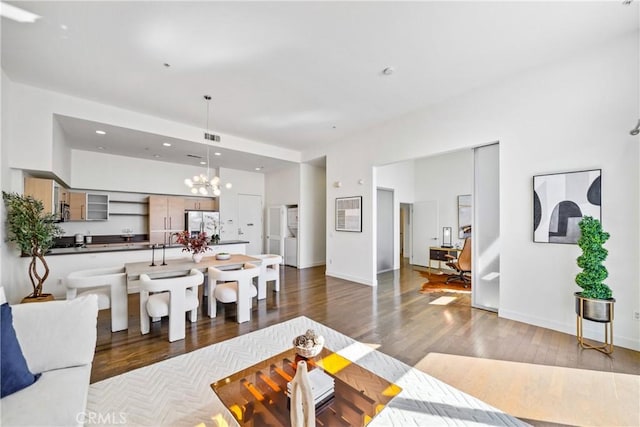 living room featuring wood finished floors, baseboards, a notable chandelier, visible vents, and recessed lighting