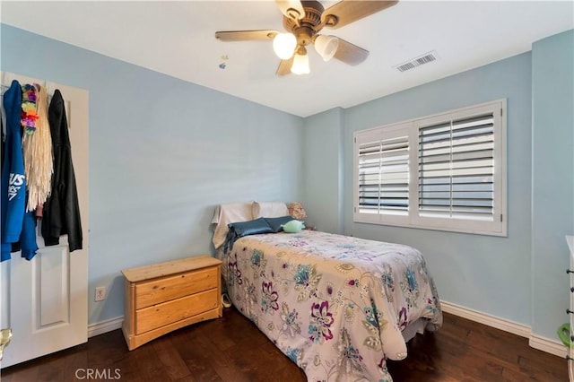 bedroom featuring dark wood-style floors, a ceiling fan, visible vents, and baseboards