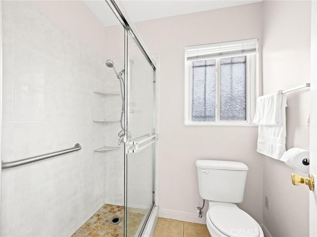 bathroom with tile patterned floors, a shower with shower door, and toilet