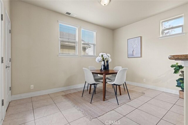 dining area featuring baseboards, visible vents, and light tile patterned floors