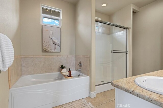 full bathroom with a stall shower, tile patterned flooring, a bath, and vanity