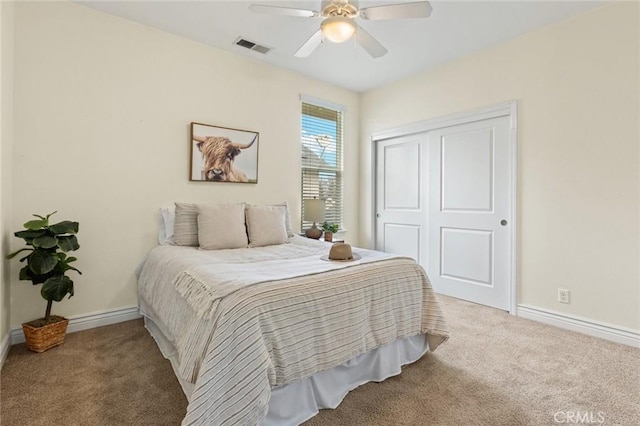 carpeted bedroom with ceiling fan, baseboards, visible vents, and a closet