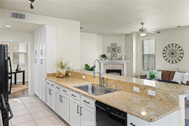 kitchen featuring white cabinets, black appliances, visible vents, open floor plan, and a sink