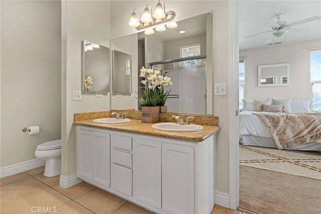 ensuite bathroom featuring baseboards, toilet, connected bathroom, and a sink