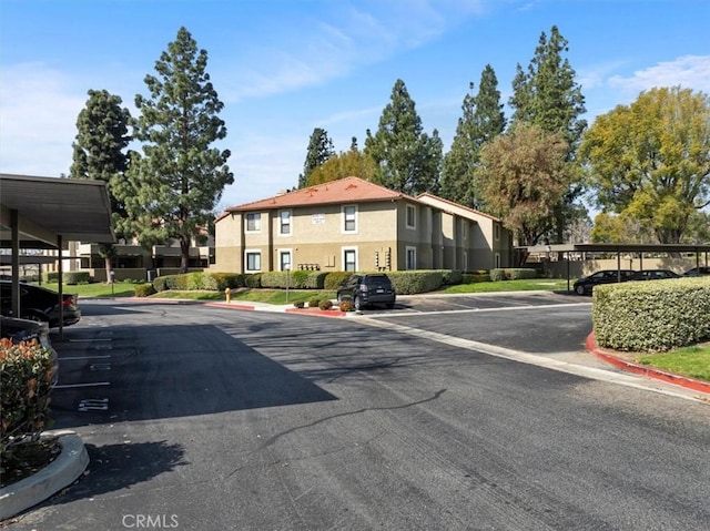 view of asphalt street featuring curbs and a residential view