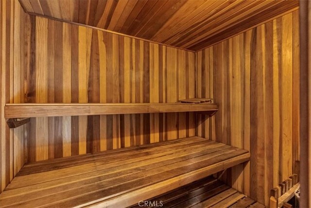 sauna / steam room with wooden ceiling and wooden walls