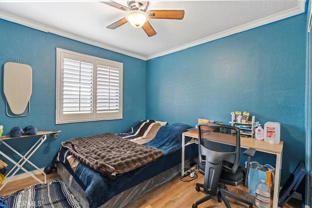 bedroom featuring ornamental molding, ceiling fan, and wood finished floors