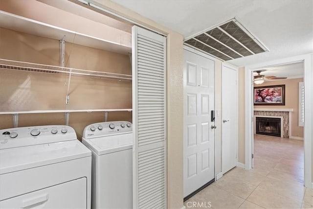 10151 Arrow Rte Unit 123, Rancho Cucamonga, CA 91730 - laundry area featuring light tile patterned floors, a fireplace, ceiling fan, washing machine and dryer, and baseboards