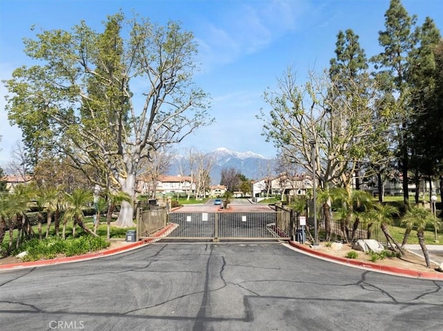 10151 Arrow Rte Unit 123, Rancho Cucamonga, CA 91730 - view of asphalt street featuring curbs, a gate, a residential view, a mountain view, and a gated entry