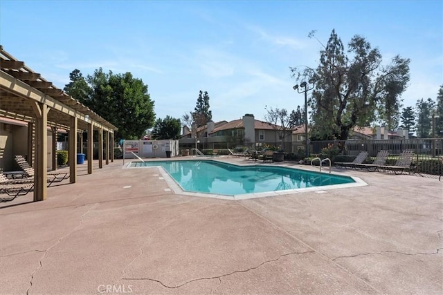 community pool with a residential view, fence, and a patio