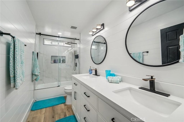 full bathroom with toilet, wood-type flooring, combined bath / shower with glass door, and vanity