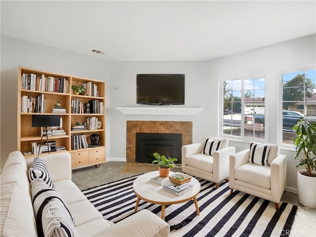 carpeted living area with visible vents, a fireplace, and baseboards