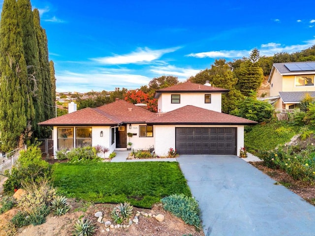 view of front of house featuring an attached garage, a chimney, concrete driveway, and a front yard