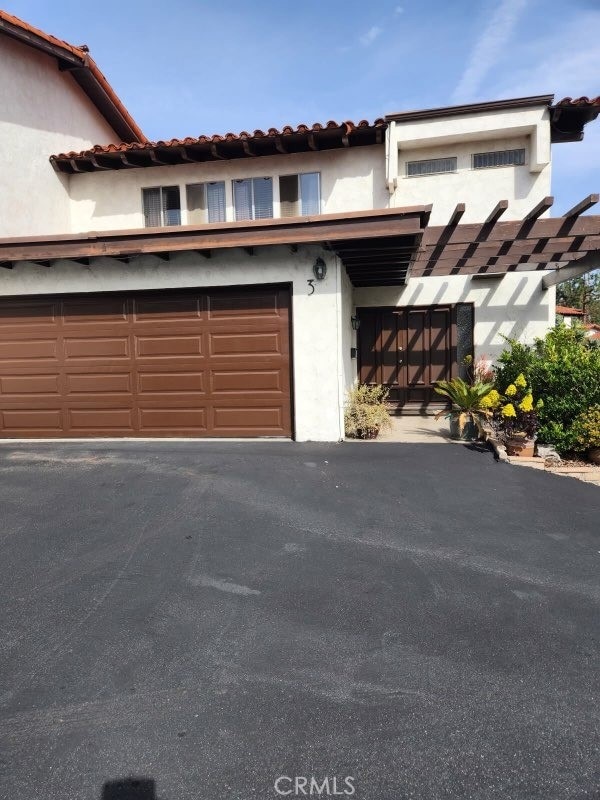 view of front facade featuring a garage, driveway, and stucco siding