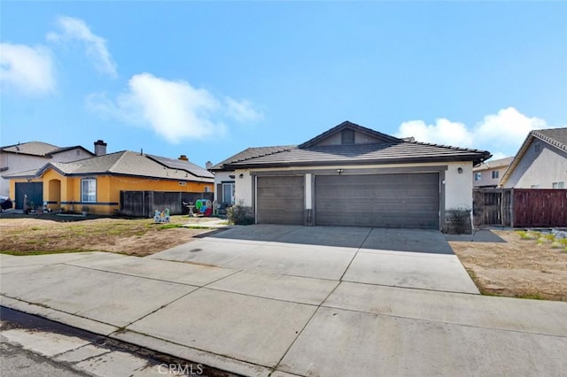 view of front of property with fence, driveway, an attached garage, and stucco siding