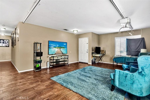 living area with visible vents, baseboards, and wood finished floors