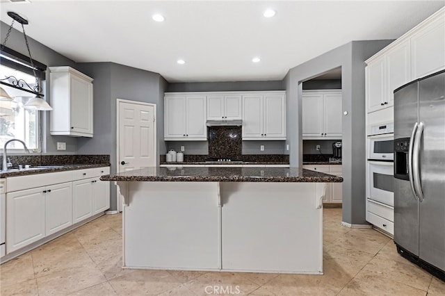 kitchen with stainless steel refrigerator with ice dispenser, white cabinets, a kitchen island, a sink, and under cabinet range hood