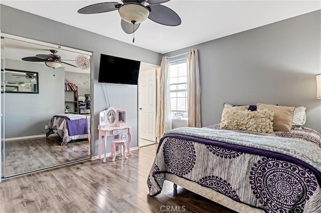 bedroom featuring wood finished floors, a ceiling fan, and baseboards