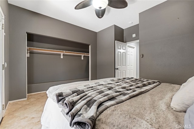 bedroom featuring a ceiling fan, a closet, light tile patterned flooring, and baseboards