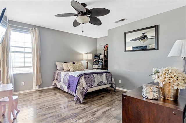 bedroom with visible vents, ceiling fan, baseboards, and wood finished floors