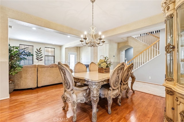 dining area featuring stairs, arched walkways, visible vents, and light wood-style floors