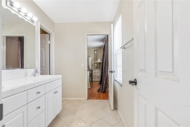 bathroom featuring vanity, baseboards, and tile patterned floors