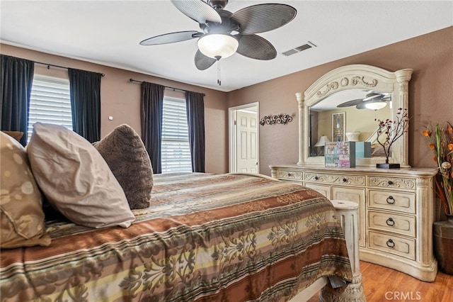 bedroom featuring ceiling fan, light wood-type flooring, and visible vents