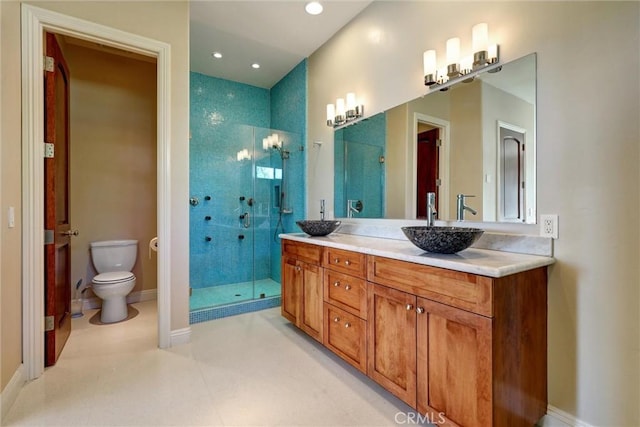 bathroom with a shower with shower door, vanity, and toilet