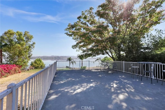 wooden deck featuring a patio and a water view