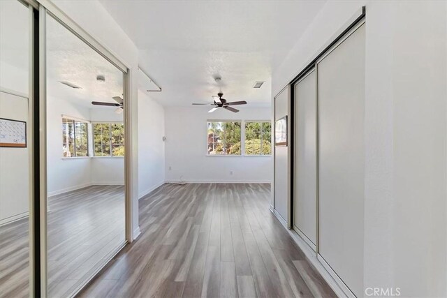 hall with light wood-style floors and baseboards