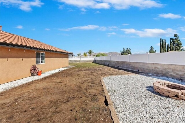 view of yard featuring an outdoor fire pit and a fenced backyard