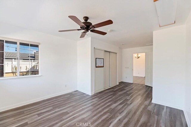 unfurnished room with ceiling fan, baseboards, and wood finished floors