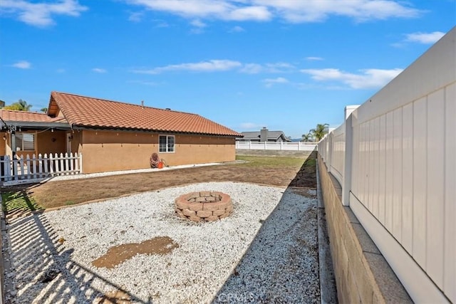 view of yard featuring an outdoor fire pit and a fenced backyard