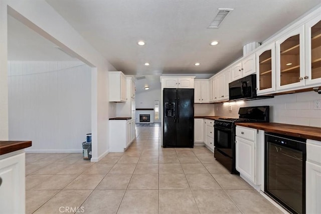 kitchen featuring beverage cooler, visible vents, white cabinetry, black appliances, and glass insert cabinets